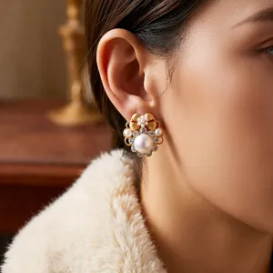 Vintage pearl flower earrings with gold petals and rhinestones worn by a model