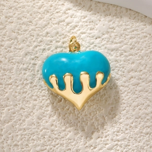 Close-up of heart pendant with blue enamel drip effect and gold-tone metal frame