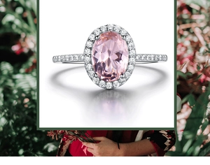 Close-up of an oval pink morganite silver ring with a sparkling halo and diamond band