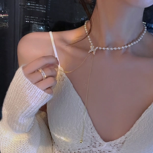 Détail d'un collier de perles papillon avec glands brillants sur fond de ville nocturne