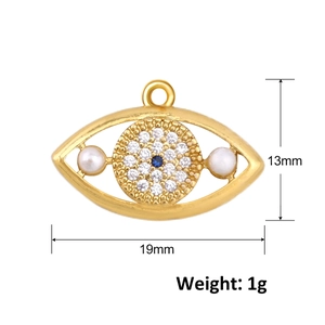Macro detail of gold zircon evil eye charm with blue stones and white pearls 19x13mm