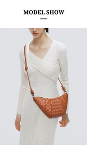 Brown woven crescent bag worn cross-body style showing the premium soft leather texture