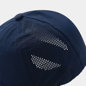 Detail of dark blue baseball cap with laser-cut ventilation holes and quick-dry fabric texture