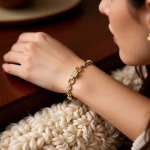 Detail of elegant gold-plated square link bracelet with cubic zirconia on female wrist