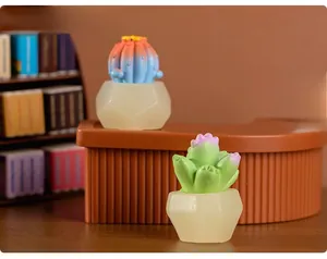 Miniature resin succulents in frosted geometric pots set on a cozy tiny office desk setup