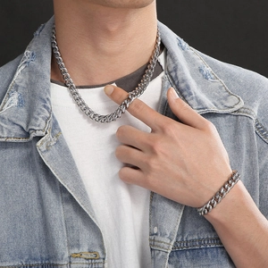Close-up of men's silver titanium steel Cuban chain necklace and bracelet on a model