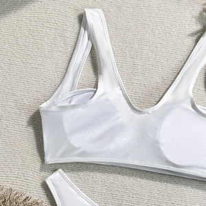 Detail of white glossy nylon bikini top with wide straps and smooth satin texture