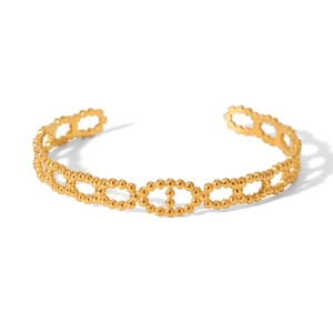 Détail d'un bracelet jonc ouvert en acier inoxydable doré avec texture perlée