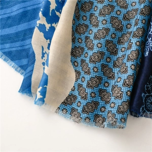 Close-up of soft floral cotton scarf featuring blue stripe patterns and fringe detail