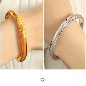 Close-up of polished gold and silver thick C-shape bangles with mirror finish