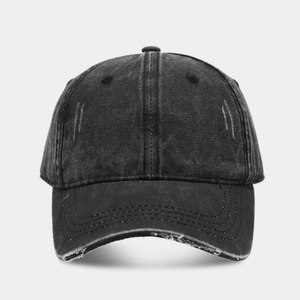 Detailed macro view of distressed brim edges on a charcoal washed cotton baseball cap