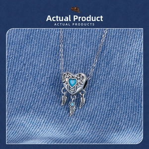 Macro detail of S925 silver heart dreamcatcher pendant with blue stone and feathers