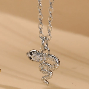 Macro shot of silver snake pendant necklace featuring intricate zircon stone embellishments