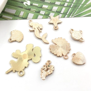 Back view of diverse gold metal charms including stars and shells for DIY jewelry crafts