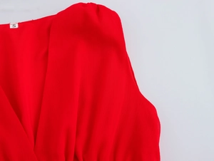Detailed close-up of textured red fabric showing the sleeveless V-neckline and S size label