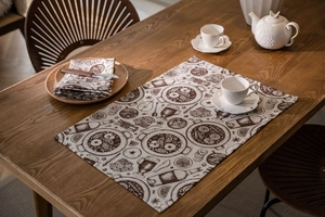 Macro shot of retro printed fabric placemat with lemon and bottle motifs on a dark wood table