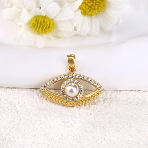 Macro shot of gold-plated evil eye pendant with pearl and sparkling zircon accents