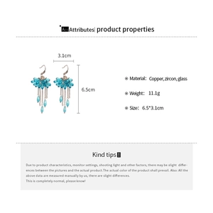 Detailed view of blue tassel earrings made of copper, zircon, and glass beads