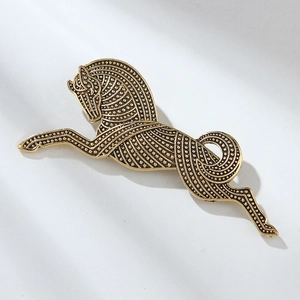 Macro view of vintage gold horse brooch with intricate dot and line textured patterns