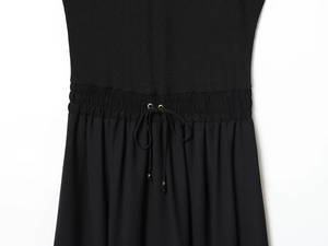 Detail of the elastic drawstring waist with gold metallic tips on a black patchwork dress