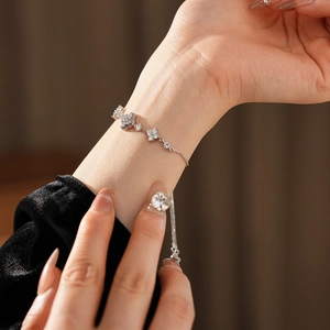 Close-up of gold-plated flower bracelet with zircons worn on wrist in a home setting