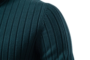 Detailed close-up of vertical ribbed texture and shoulder seam on dark green knit sweater