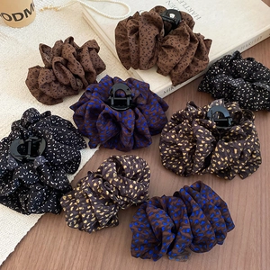 Pinces à cheveux rétro en tissu imprimé léopard et fleurs sur une table en bois