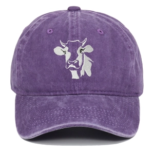 Detail of purple washed cotton fabric and white cow head embroidery on baseball cap