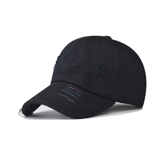 Detail view of washed black distressed baseball cap with metal rings on the brim