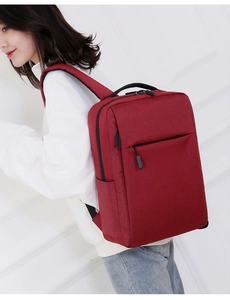 Close-up of a red minimalist business laptop backpack worn by a female model