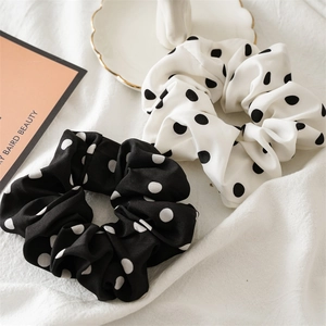 Set of two black and white polka dot fabric scrunchies with elegant bow ribbons