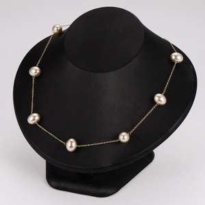 Elegant vintage gold chain necklace with baroque pearls on a black jewelry mannequin