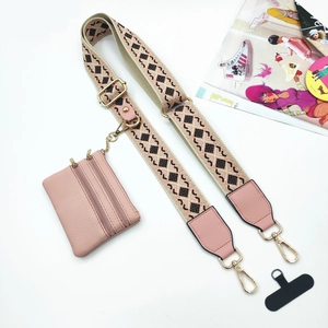 Dettaglio della pochette rosa e della tracolla intrecciata con motivi geometrici