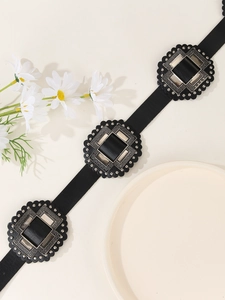 Detail of black PU leather belt featuring three ornate vintage western square metal buckles