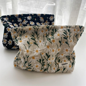 Floral daisy embroidered makeup bags in black and beige canvas with Sozakka label