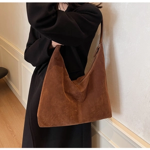 Detail view of large dark brown suede hobo bag styled for high-end commuter outfits