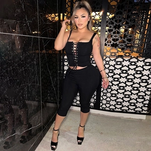 Detail of ribbed knit two-piece set featuring lace-up crop top and slim fit pants