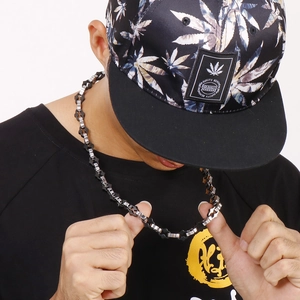 Detail of masculine hip hop chain necklace featuring industrial gear links in silver and black
