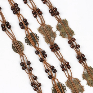 Close-up of Bohemian hand-woven waist belts with brown beads and bronze metal butterfly charms