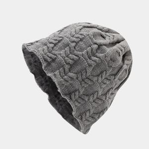 Close-up of dark grey knit beanie showing thick cable pattern and texture