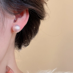 Close-up of elegant 10-12mm lavender pearl stud earring worn on model's ear lobe