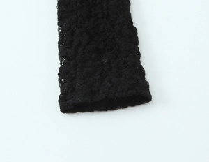 Close-up of intricate black lace sleeve cuff with delicate floral patterns and mesh detail