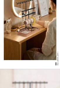 Detail view of multi-tier jewelry stand with necklace hooks and wooden ring tray storage