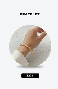 Detail of a 18k gold plated twisted bamboo style bangle on a model's wrist