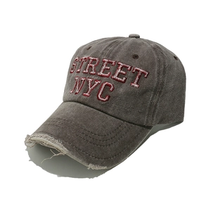 Dettaglio del berretto da baseball marrone lavato con ricamo Street NYC e visiera usurata