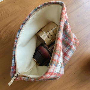Detail view of plaid tweed makeup bag with thick lining and silver metal zipper