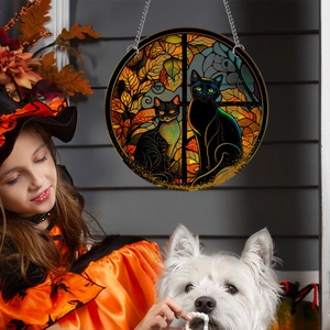 Halloween suncatcher with black cats in autumn leaves, held by girl in costume
