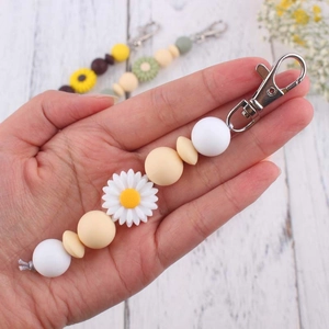 Handmade daisy silicone bead keychain with white and yellow beads and lobster clasp