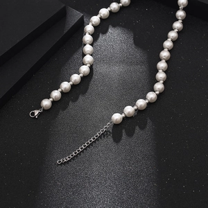 Detail of white pearl necklace with silver spacer beads and lobster claw clasp closure