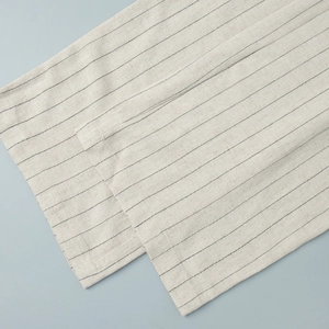 Close-up of striped cotton linen fabric texture with neat stitching and beige background